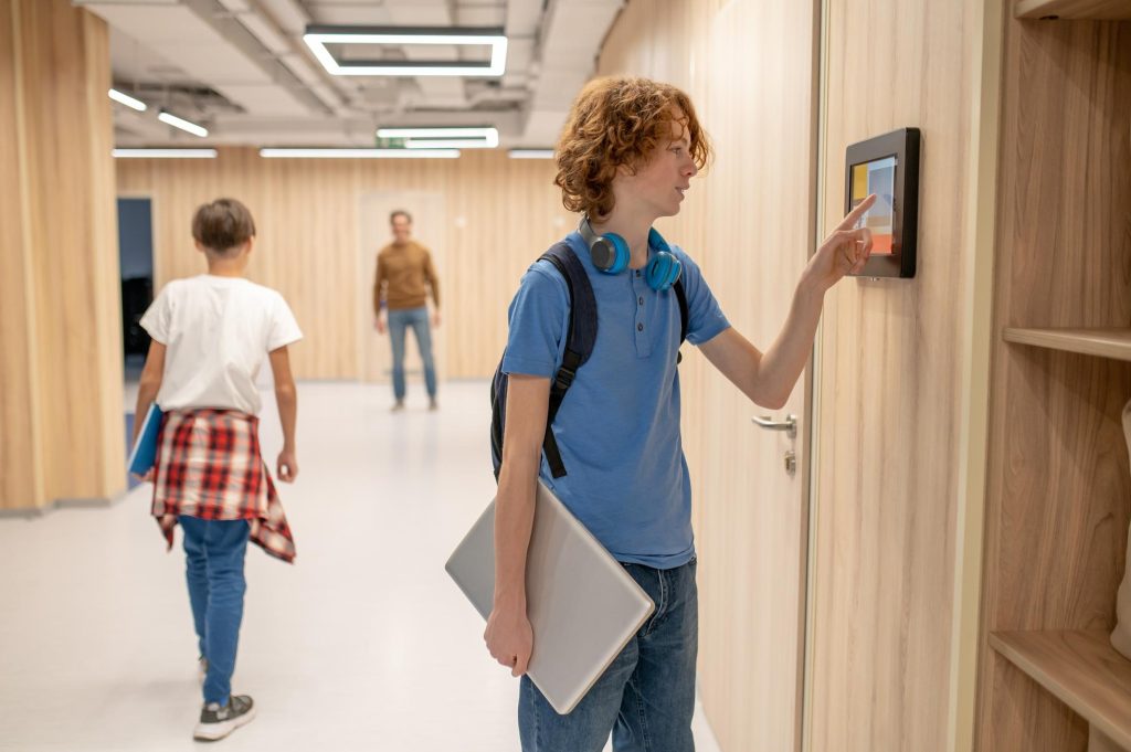 Child scanning fingerprint for attendance.